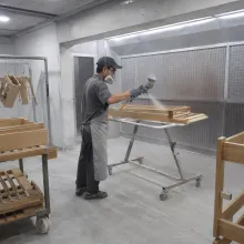 Spray booth in operation with finished units on the drying rack