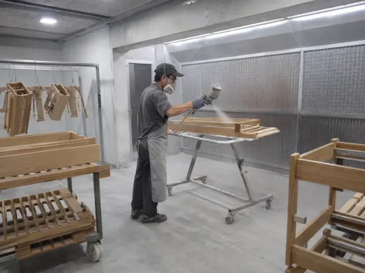 Spray booth in operation with finished units on the drying rack